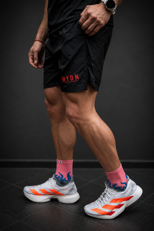 Short HYDN negro en contexto de running con zapatillas de competición